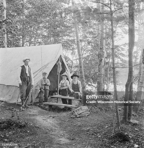 Dr Smith's brother-in- law, Franklin E Bump, and three of his children, Franklin E Jr, Warner, and Millard Bump, standing in front of a tent in the...