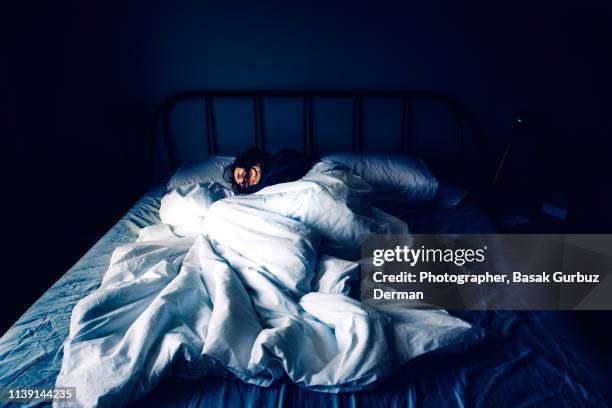 a woman sleeping in bed at night time - negative emotion stock pictures, royalty-free photos & images