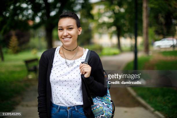gelukkige vrouwelijke student op universitaire campus - cute college girl stockfoto's en -beelden