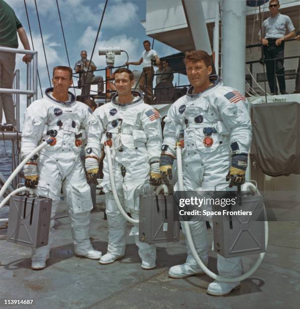 The prime crew of the first manned Apollo space mission, Apollo 7, on the deck of the NASA Motor Vessel Retriever after suiting up for water egress...