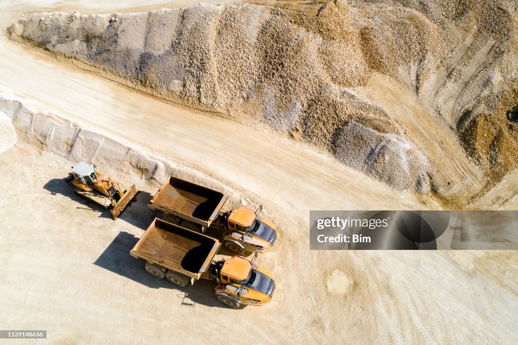 Dump Trucks and Bulldozer in a Quarry, Aerial View