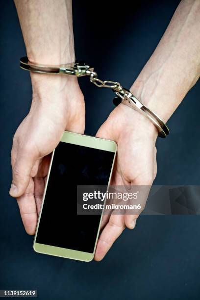 handcuffed to internet, smartphone addiction - handcuffs imagens e fotografias de stock