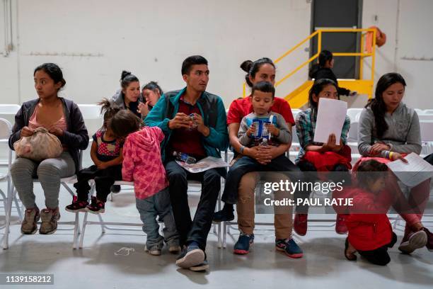 Migrants from Honduras and other countries wait to make phone calls and travel arrangements to their family in friends who host them in the United...