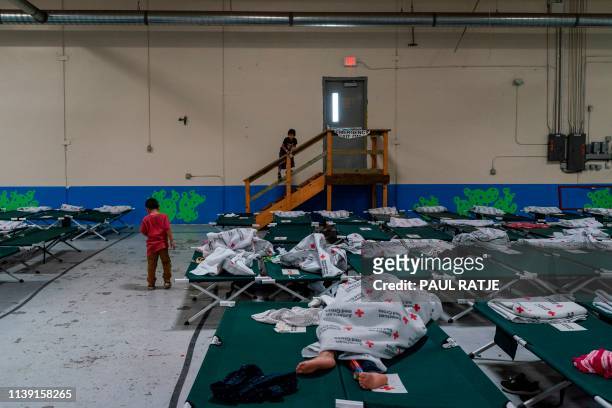 Migrant children from different Latin American stand near rows of cots inside the Casa del Refugiado, or The House of Refugee, a new centre opened by...