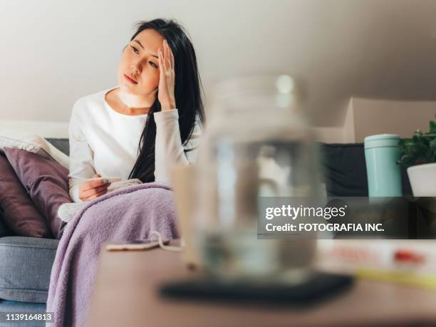 jonge aziatische vrouw ziek thuis - electric blanket stockfoto's en -beelden