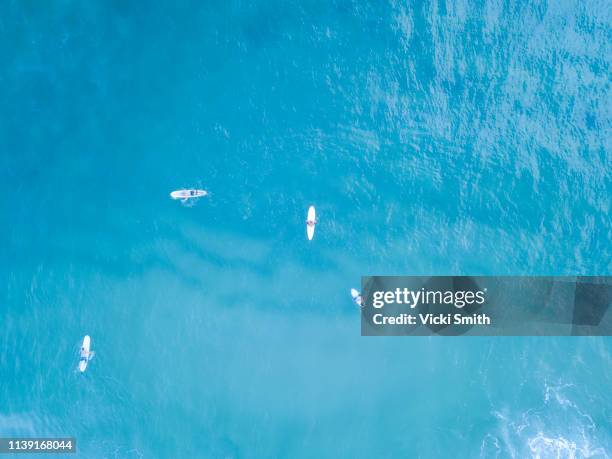 ocean waters with surfers seen from above - sunrise over water stock pictures, royalty-free photos & images