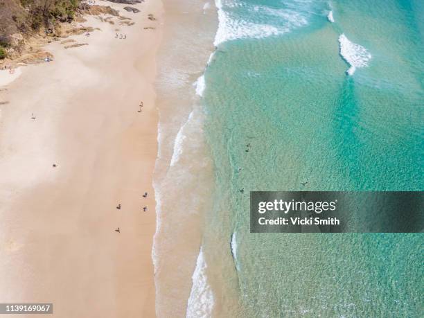 ocean waters with surfers seen from above - byron bay stock-fotos und bilder