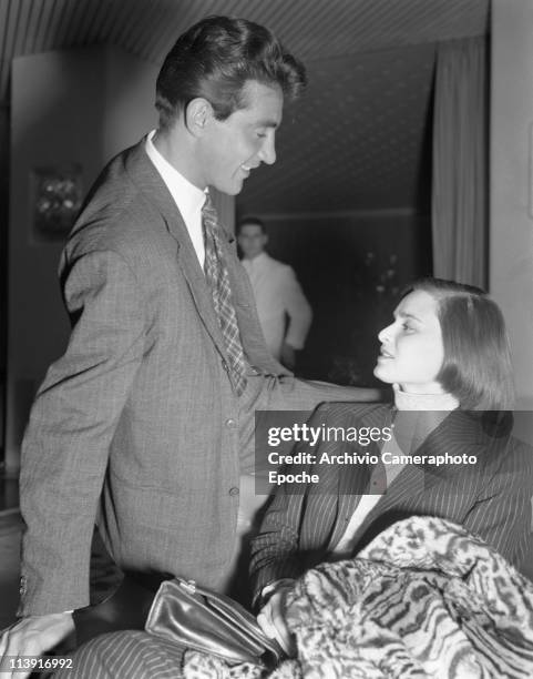 Italian actress Lucia Bose with her partner Walter Chiari, sitting and chatting in an hotel hall in Venice, 1947. She is wearing a pinstriped...