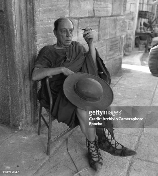 American actor Joseph 'Buster' Keaton, wearing a roman armor and smoking a cigarette, resting during the shooting of ' A Funny Thing Happened on the...