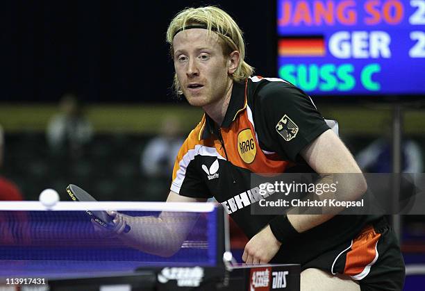 Christian Suess of Germany plays a forehand against Jan Song Man of North-Korea during the first round Men's Single match during the World Table...