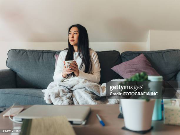 jonge aziatische vrouw ziek thuis - electric blanket stockfoto's en -beelden