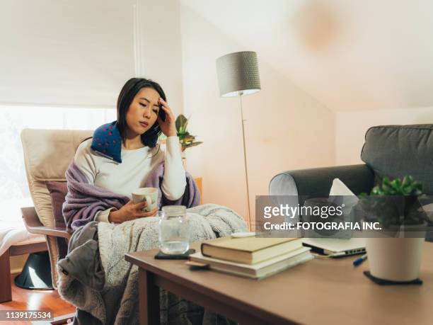 jonge aziatische vrouw ziek thuis - electric blanket stockfoto's en -beelden