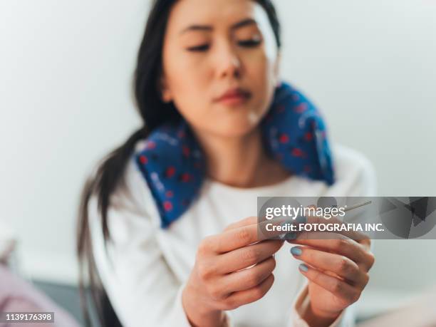 jonge aziatische vrouw ziek thuis - electric blanket stockfoto's en -beelden