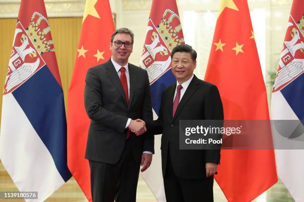 Serbian President Aleksandar Vucic, left, shakes hands with Chinese President Xi Jinping, right, before the meeting at the Great Hall of People in...