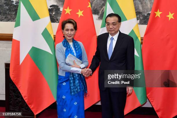 Myanmar's State Counsellor Aung San Suu Kyi, left, shakes hands with Chinese Premier Li Keqiang as they pose for media before their meeting on April...