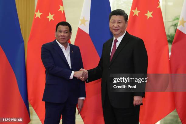 Philippine President Rodrigo Duterte, left, shakes hands with Chinese President Xi Jinping, right, before the meeting at the Great Hall of People in...