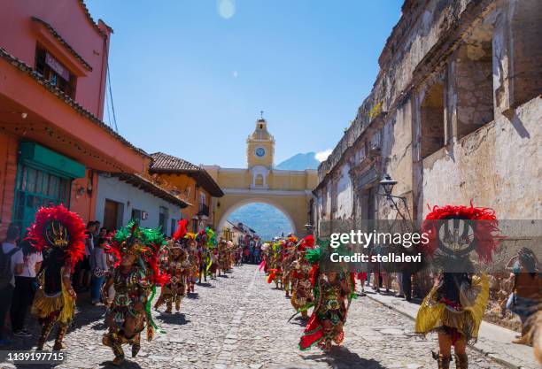 antigua gatuvy med berömda santa catalina båge, traditionella dansare, och agua vulkan utsikt - traditional festival bildbanksfoton och bilder