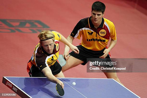 Christian Suess and Dimitrij Ovtcharov of Germany in action during his first round Men's Double match against Alfredo Carneros and Carlos Machado of...