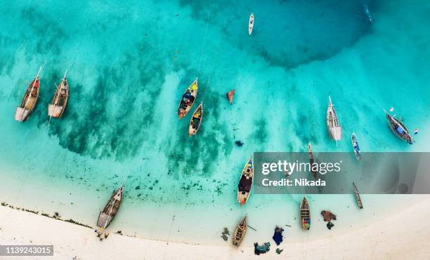 barcos en la hermosa playa de zanzíbar, áfrica - zanzibar fotografías e imágenes de stock