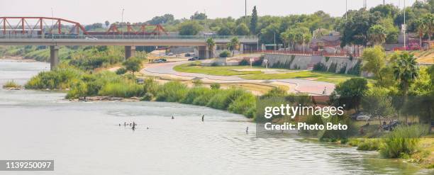 the us-mexico border along the rio grande river between the cities of eagle pass and piedras negras - sinal travessia de imigrantes imagens e fotografias de stock
