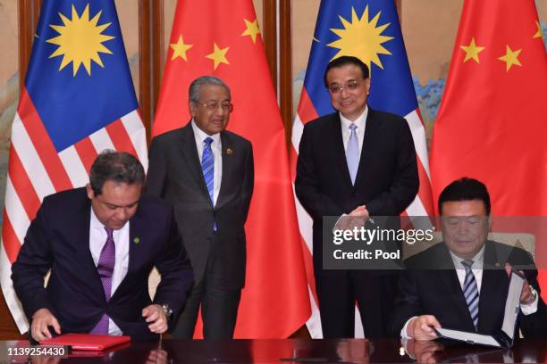 Malaysia's Prime Minister Mahathir Mohamad, speaks with Chinese Premier Li Keqiang as they pose for media after a signing ceremony on April 25, 2019...