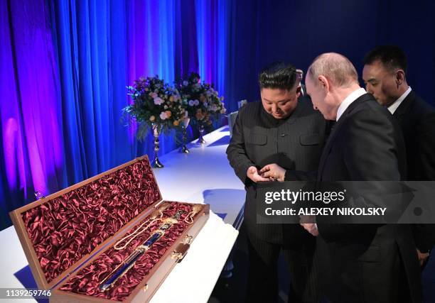 Russian President Vladimir Putin and North Korean leader Kim Jong Un exchange gifts following their talks at the Far Eastern Federal University...