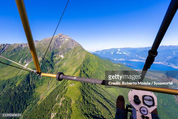 hang glider flying over lake como, italy - gleiten stock-fotos und bilder