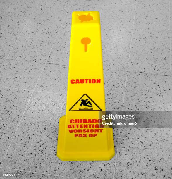 caution slippery surface sign on wet floor - safety cone stock-fotos und bilder