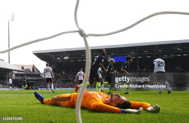 Sergio Rico of Fulham reacts as Bernardo Silva of Manchester City celebrates with teammates after scoring his team's first goal during the Premier...