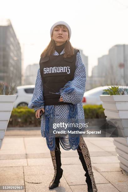 Guest is seen on the street attending Labelhood during Shanghai Fashion Week A/W 2019/2020 wearing Sankuanz black utility vest, blue/white pattern...