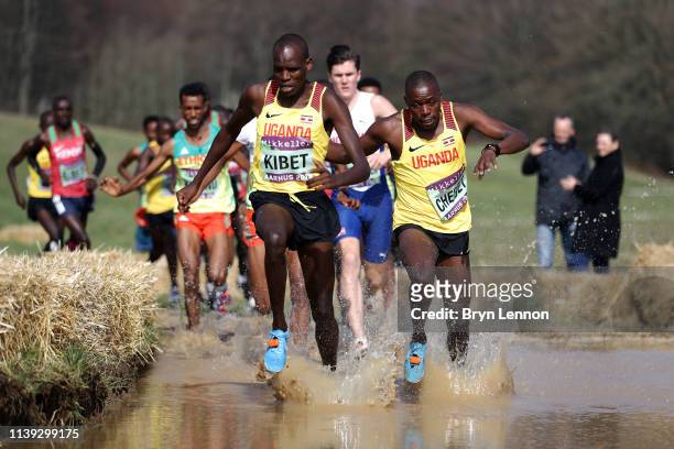 Samuel Kibet of Uganda leads through the watersplash on the first lap of the Senior Men's race at the IAAF World Athletics Cross Country...