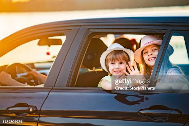 kinder winken durch autofenster - ausgangslage stock-fotos und bilder