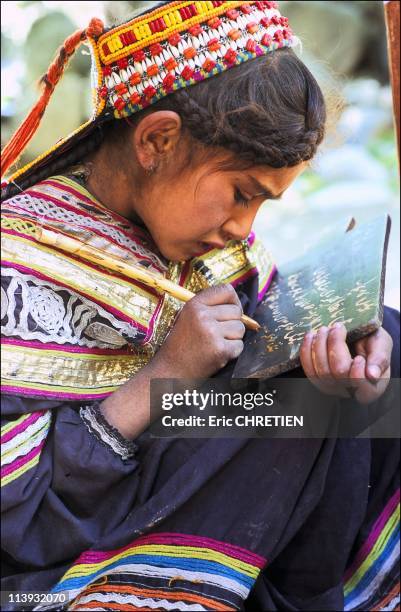 Kalash Schoolgirl, In Pakistan In 2001-A piece of wood soaked in liquid mud is sufficient to teach children how to write. Kalash school of Brun,...