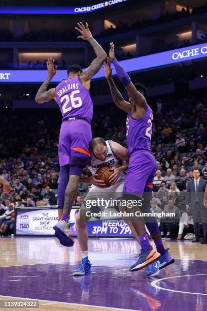 Kosta Koufos of the Sacramento Kings is defended by Ray Spalding and Deandre Ayton of the Phoenix Suns at Golden 1 Center on March 23, 2019 in...