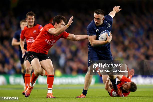 Jack Conan of Leinster breaks the tackle of Michael Lowry and Jacob Stockdale of Ulster during the Champions Cup Quarter Final match between Leinster...