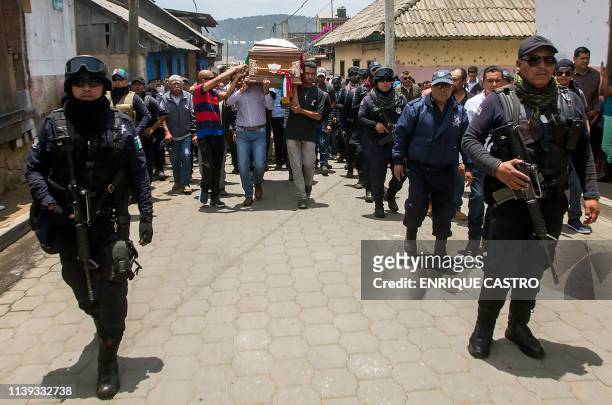 Police guard as relatives and friends of Nahuatzen Mayor, David Otilica, carry his coffin during his funeral in Nahuatzen, Michoacan State, Mexico on...