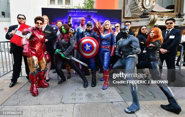 Fans of the Avengers strike a pose while dressed in costumes for a costume contest before the first screening of "Avengers: Endgame" at the TCL...