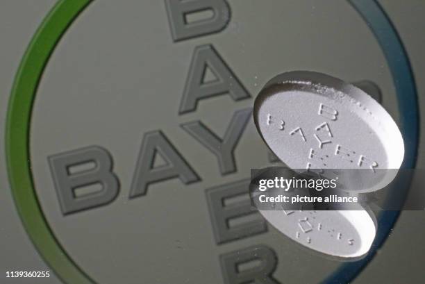 April 2019, North Rhine-Westphalia, Cologne: An Aspirin tablet stands in front of a Bayer logo on a mirror. Bayer stockholders will meet for the...