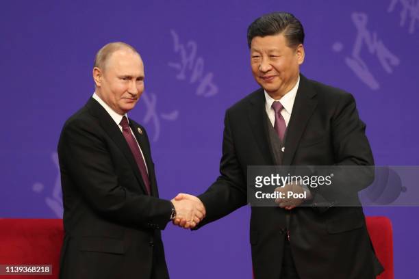 Russian President Vladimir Putin, left, shakes hands with Chinese President Xi Jinping, right, during the Tsinghua Universitys ceremony, at...