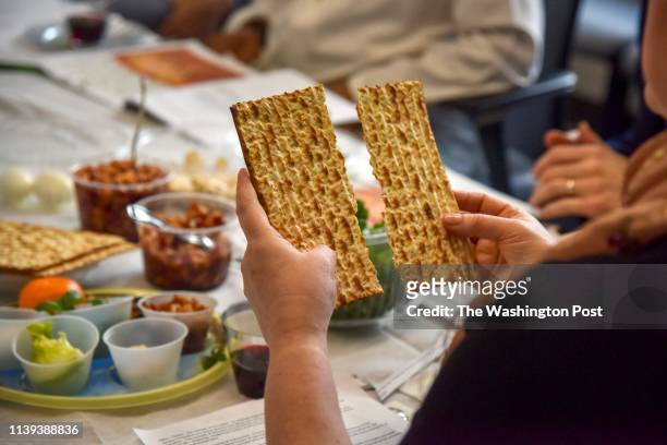 Rabbi Janet Ozur Bass breaks a piece of unleavened bread at an Interfaith Passover seder hosted by Montgomery County council member Sidney Katz at...