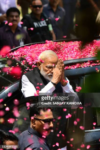 Indian Prime Minister and leader of the Bharatiya Janata Party Narendra Modi gestures to supporters as he arrives to file his election nomination...