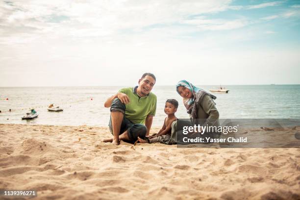 family portrait on a beach - muslim woman beach stock pictures, royalty-free photos & images