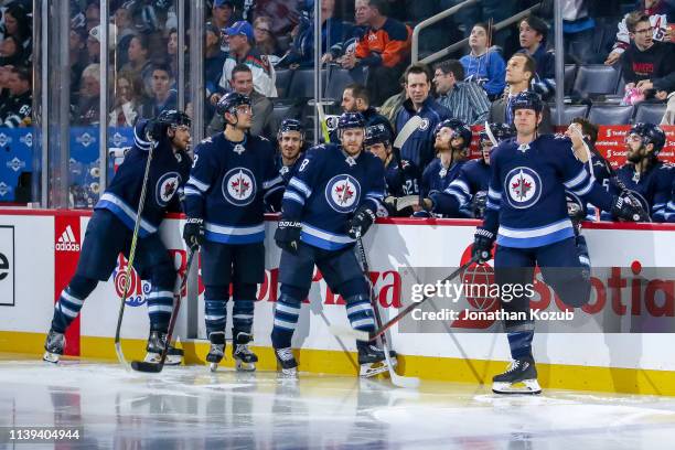 Bryan Little and Matt Hendricks of the Winnipeg Jets look on as they await the presentation of team awards prior to NHL action against the New York...