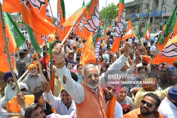 Supporters of the Bharatiya Janata Party wave party flags during a rally in support of candidate for Amritsar's parliament seat Hardeep Singh Puri,...