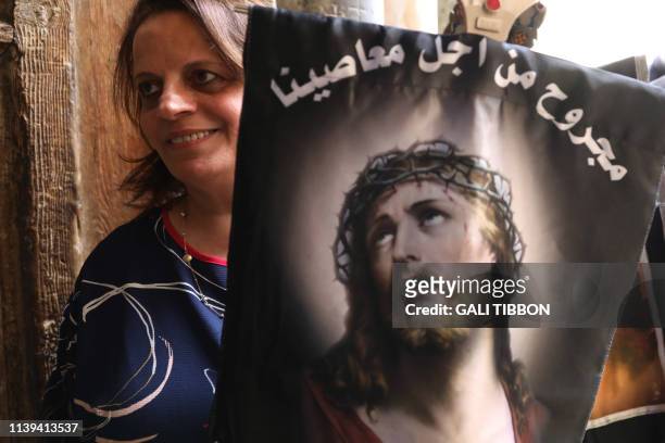 Coptic Orthodox pilgrim, carrying a cross and a banner with the face of Jesus along the Via Dolorosa , enters the church of the Holy Sepulchre in...