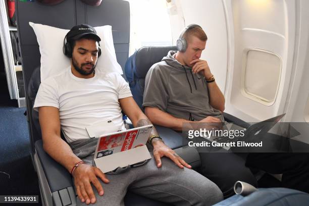 Trey Lyles and Mason Plumlee of the Denver Nuggets watch their tablets on a plane to San Antonio on April 24, 2019 at Denver International Airport in...