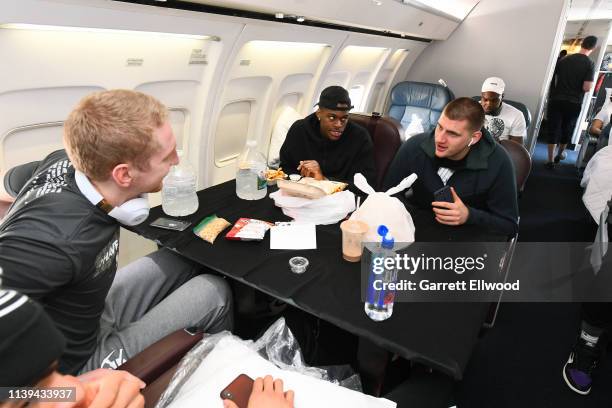 Nikola Jokic and Thomas Welsh of the Denver Nuggets talk on a plane ride to San Antonio on April 24, 2019 at Denver International Airport in Denver,...
