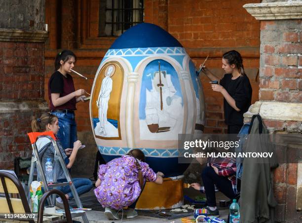 Young artists paint a giant Easter egg in the yard of an Orthodox monastery in central Moscow on April 26 ahead of the Orthodox Easter on April 28,...