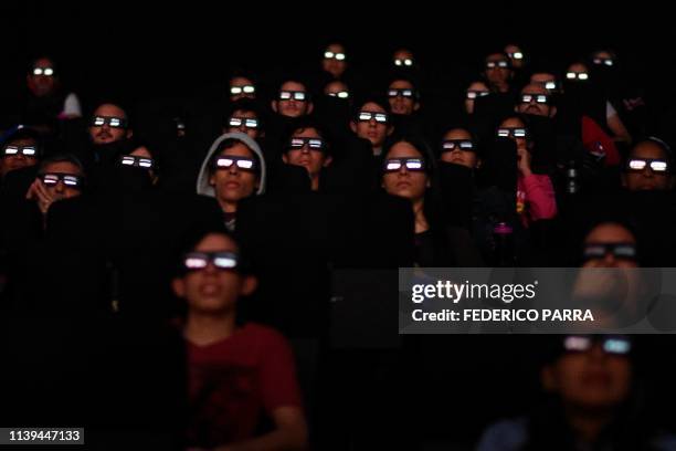 Venezuelan filmgoers watch the first screening in Venezuela of Marvel Studios' "Avengers: Endgame" at a cinema in Caracas on early April 26, 2019....