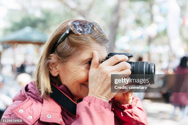 senior woman taking pictures - old photographer stock pictures, royalty-free photos & images